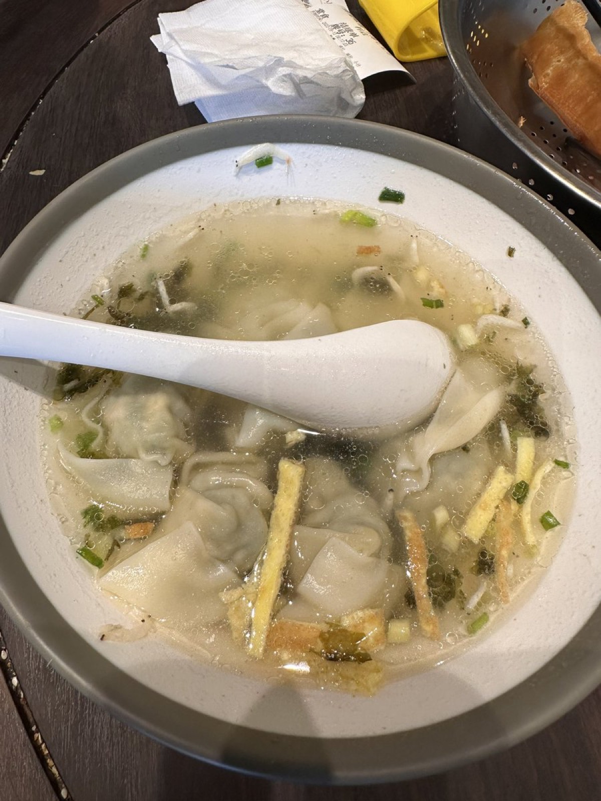 A Shanghai breakfast table with savory soy milk, fried dough sticks, a sticky-rice roll and wontons